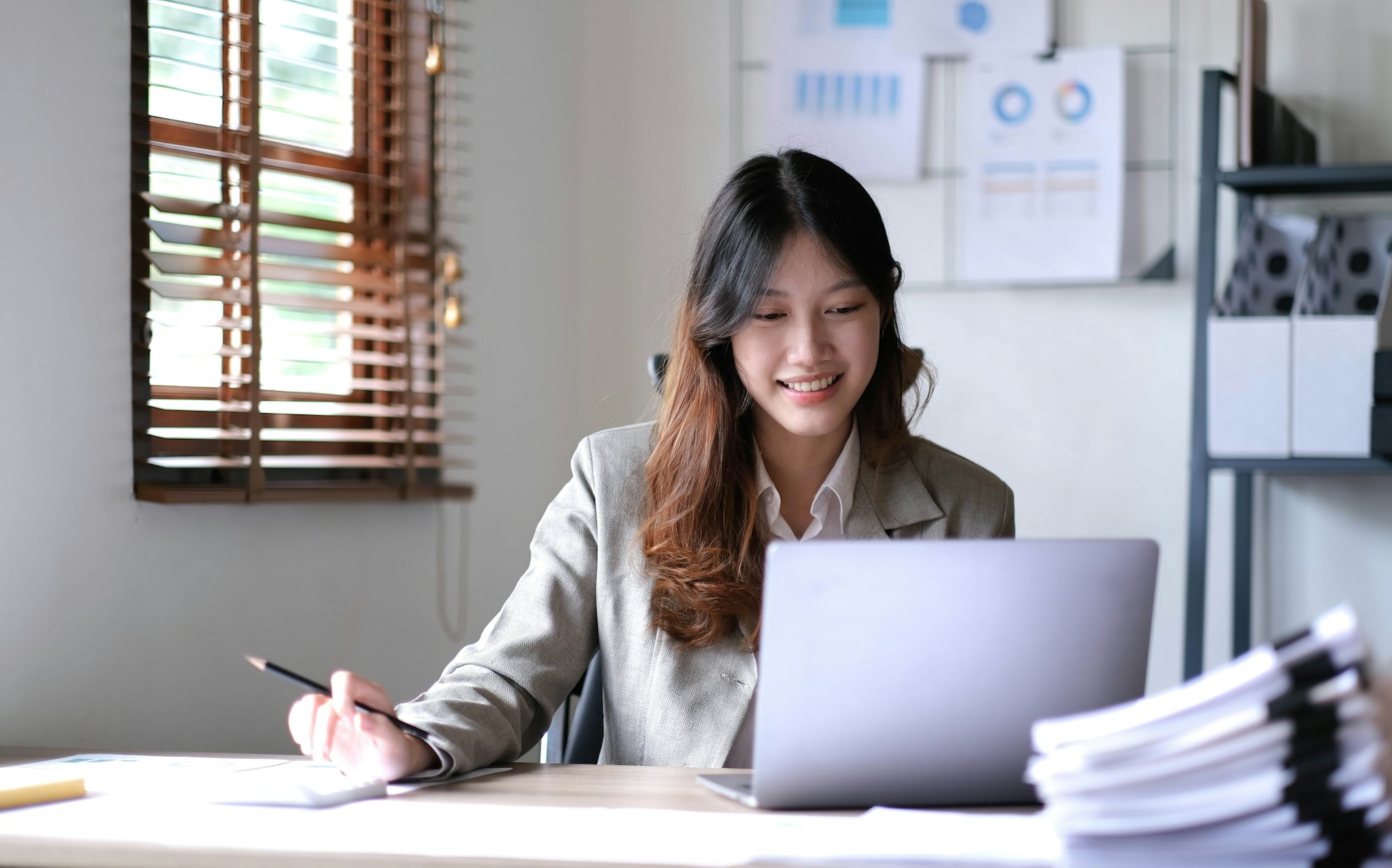 young smiling Asian businesswoman working on laptop. Asia businesswoman working document finance